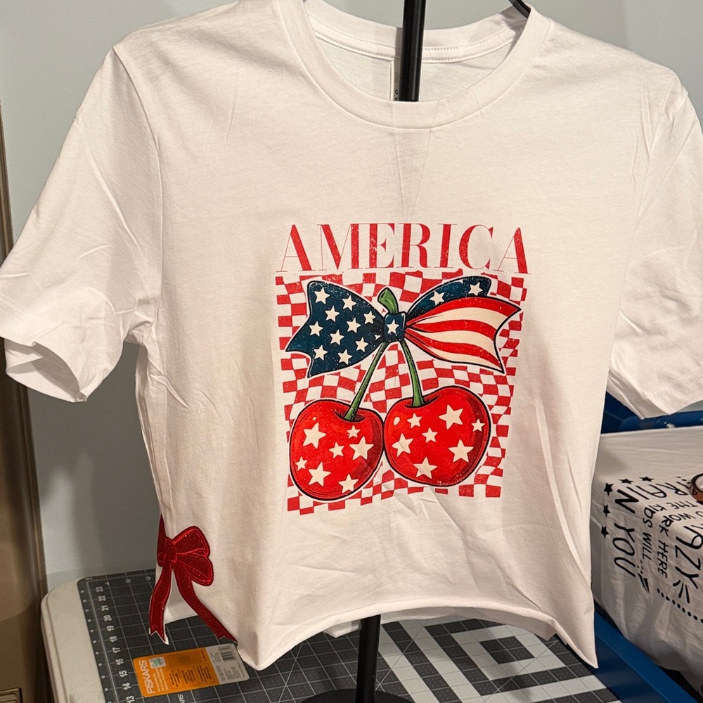 White women's America Graphic T‑Shirt with Red Cherry Print with bows on the Sid